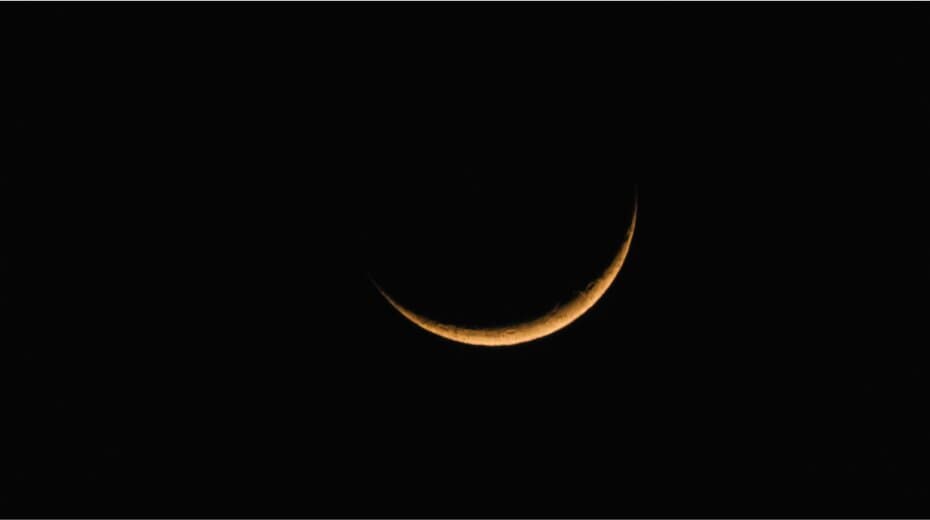 Crescent moon glowing against a dark sky.